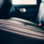 Detail of a stitch of an elegant car seats upholstered in black handmade leather. Side view