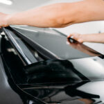 Male specialist with car tinting film in hands