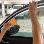 Technician Installing car window tint.