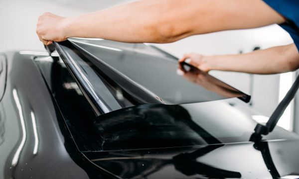 Male specialist with car tinting film in hands