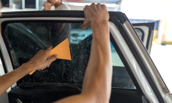 Technician Installing car window tint.